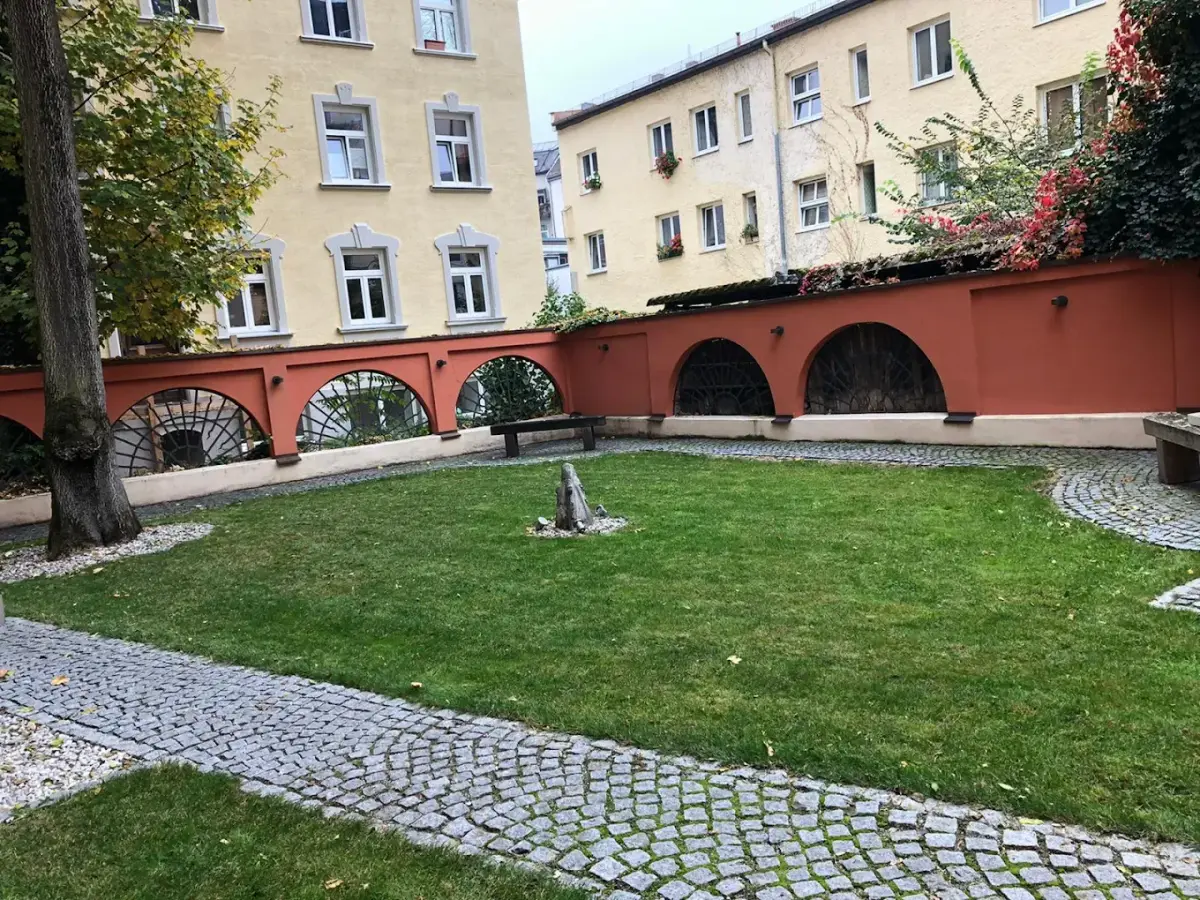 Gepflegter Innenhof mit frisch gemähtem Rasen und Kopfsteinpflaster